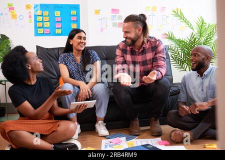 Group of diverse colleagues brainstorm together, informal meeting sit on floor Stock Photo