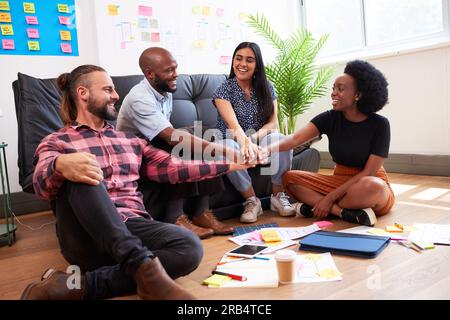 Multiracial group of colleagues put hands together in stack, celebrate teamwork Stock Photo