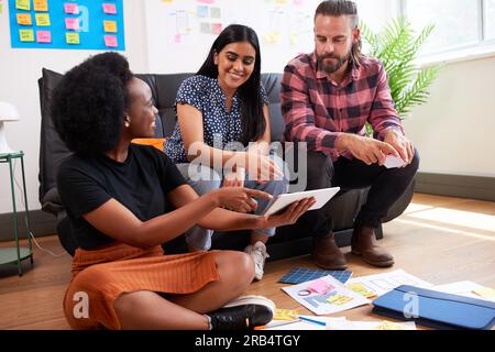 Group of diverse colleagues brainstorm together, informal meeting sit on floor Stock Photo