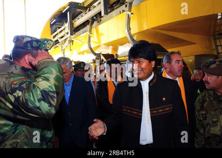 El Alto, Bolivia, 15th September 2014. Bolivian president Evo Morales (centre) greets an army officer as he arrives at the station in Ciudad Satelite for the inauguration ceremony of the Yellow Line. The Yellow Line is the second of three cable car lines to be opened this year, and is part of an ambitious project to relieve traffic congestion. The first line opened in May, when all three are open they will be the world's longest urban cable car system. The system has been built by the Austrian company Doppelmayr. Stock Photo