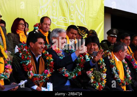 El Alto, Bolivia, 15th September 2014. Bolivian vice president Alvaro Garcia Linera (centre) takes a photo using his smartphone during the inauguration ceremony of the cable car Yellow Line, watched by president Evo Morales (right). Left of photo is the La Paz Department Governor Cesar Cocarico, on the right is Mi Teleferico CEO Cesar Dockweiler. The Yellow Line is the second of three cable car lines to be opened this year, and is part of an ambitious project to relieve traffic congestion. The first line opened in May, when all three are open they will be the world's longest urban cable car sy Stock Photo