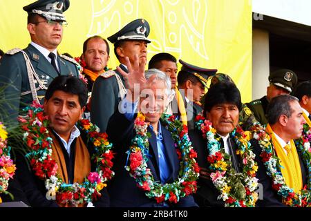 El Alto, Bolivia, 15th September 2014. Bolivian vice president Alvaro Garcia Linera (centre) waves to supporters during the inauguration ceremony of the cable car Yellow Line. President Evo Morales is next to him on the right, left of photo is the La Paz Department Governor Cesar Cocarico, far right is Mi Teleferico CEO Cesar Dockweiler. The Yellow Line is the second of three cable car lines to be opened this year, and is part of an ambitious project to relieve traffic congestion. The first line opened in May, when all three are open they will be the world's longest urban cable car system. Stock Photo