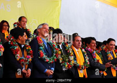 El Alto, Bolivia, 15th September 2014. Bolivian president Evo Morales (centre) and vice president Alvaro Garcia Linera (left of centre) during the inauguration ceremony of the cable car Yellow Line. Far left is the La Paz Department Governor Cesar Cocarico. The Yellow Line is the second of three cable car lines to be opened this year, and is part of an ambitious project to relieve traffic congestion. The first line opened in May, when all three are open they will be the world's longest urban cable car system. Stock Photo