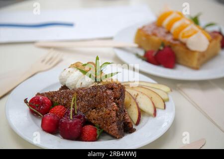 Beautifully decorated slice of cake with fresh fruits on the table in cafe Stock Photo