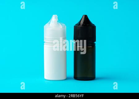 Electronic cigarettes liquid bottles on blue background Stock Photo