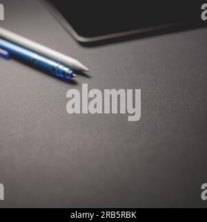 Blurry Background, Pencil and tablet on black background, business concept Stock Photo