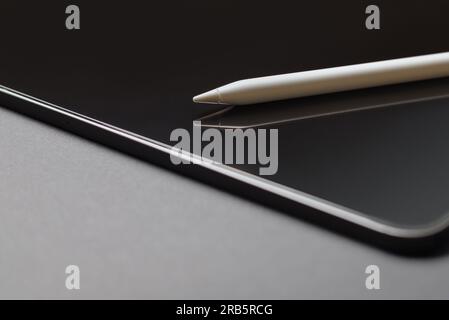 Close-up of digital tablet and pencil on grey background Stock Photo
