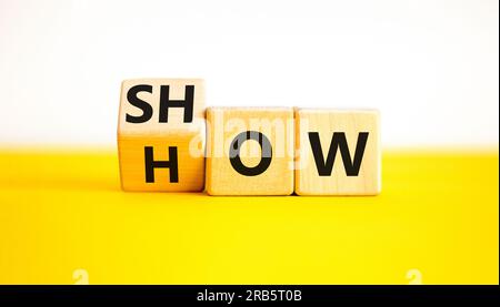 Show how symbol. Businessman turns wooden cubes and changes the word Show to How. Beautiful yellow table white background. Copy space. Business and Sh Stock Photo