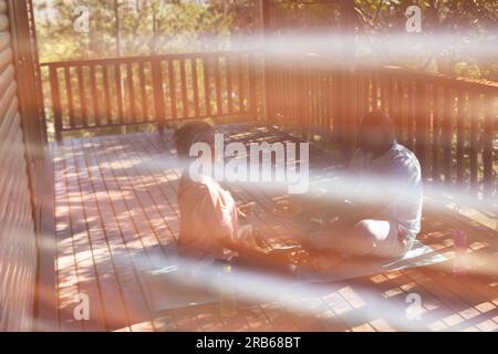 Senior african american couple practicing yoga on mat on terrace. Senior lifestyle, relaxing, retirement, healthy life, fitness, exercise and wellbein Stock Photo
