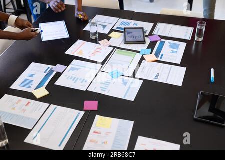 African american colleagues with documents and graphs on table discussing work in office. Business, brainstorm and teamwork, unaltered. Stock Photo