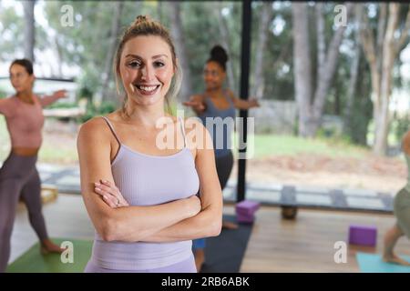 Portrait of happy caucasian woman in yoga class. Yoga, exercise, fitness and healthy lifestyle, unaltered. Stock Photo