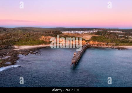 Long historic jetty at Middle Camp beach of Catherine Hill bay town on Pacific coast of Australia at sunrise. Stock Photo