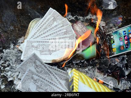 Offerings or joss papers or ghost papers being burned for a Vietnamese man,  named Thành Kot, who had died at the age of 20. Joss papers are papers made  with specific patterns, colors, and symbols to imitate valuables such as  money, gold, houses, and