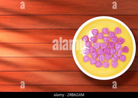 Heart shaped candies on a plate on a wooden background. Top view Stock Photo