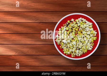 Popcorn in red bowl on wooden background. Top view. Stock Photo