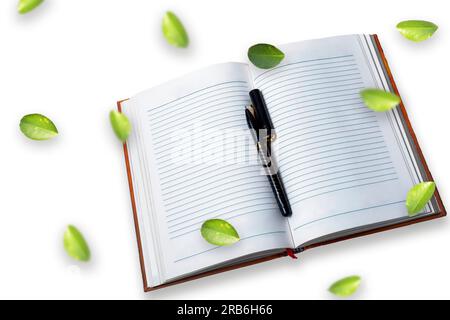 Notebook and pen with green leaves on white background Stock Photo