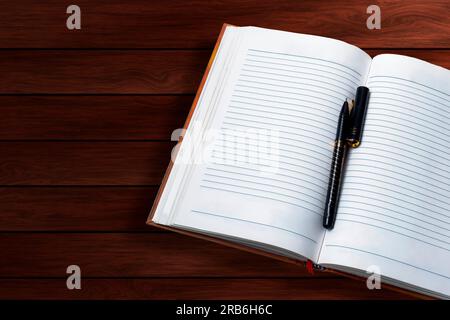 Open notebook with pen on wooden table. Top view Stock Photo