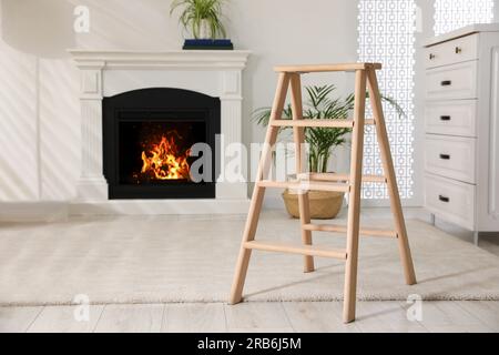 Wooden folding ladder in stylish living room Stock Photo