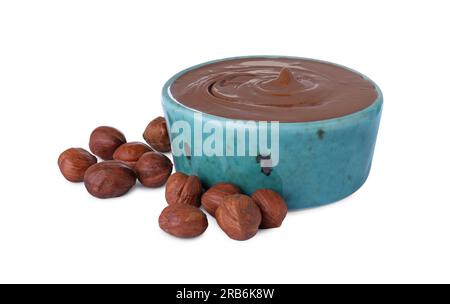 Bowl with delicious chocolate paste and hazelnuts on white background Stock Photo
