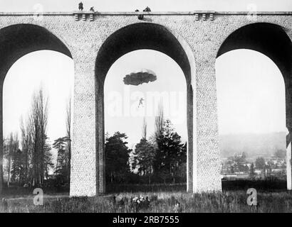 Paris, France:  December 28, 1927 Mademoiselle Bonte makes a dangerous parachute jump of only 87 feet from the viaduct of Palaiseau on the outskirts of Paris while spectators watch form above and below. Stock Photo