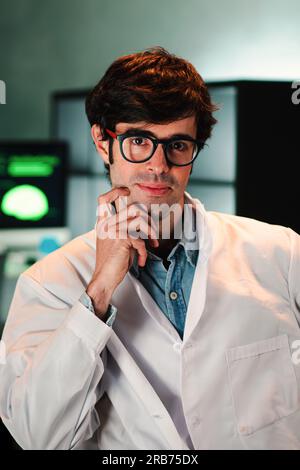 Vertical portrait of attractive medical doctor with glasses and lab coat looking at camera. Front view of handsome pharmacy scientific with goggles working on science space. Healthcare and medicine. High quality photo Stock Photo