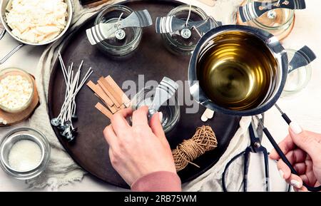 Set for homemade natural eco soy wax candles, Woman making decorative aroma candle at table Stock Photo