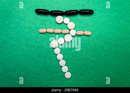 A close-up photo of a pile of colorful health care pills arranged in the shape of the Indian rupees symbol. The pills are on a plain whiteplain backgr Stock Photo