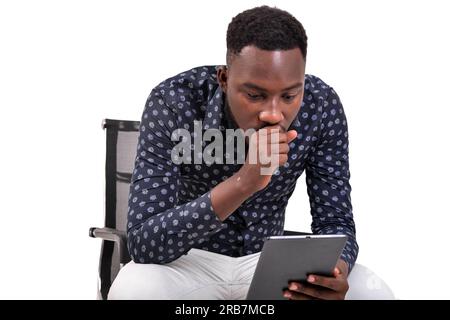 a young bearded man sitting against white background looking at tablet in amazement Stock Photo