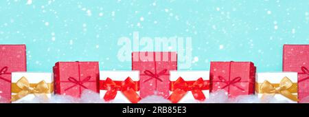 Closeup of different colorful gift boxes in a row with beautiful decorations and bows isolated on Light Blue. Gift boxes on a white table stand in a r Stock Photo