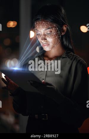Woman, tablet and facial recognition at night in biometrics for access, verification or identification at office. Female person or employee working Stock Photo