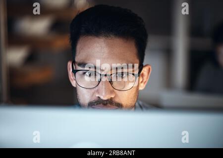 Computer, research and man in glasses for software development, night programming and cybersecurity. Reading, focus and person or programmer with data Stock Photo