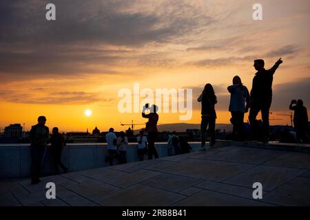 Oslo, Norway, June 20, 2023: Tourists view a sunset from the Oslo Opera House, which was built in 2008 with the intention to allow visitors to walk up Stock Photo