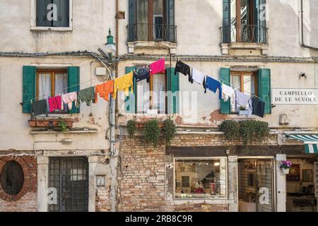 Typical scene in Campiello de le Scuole, Venice, Italy.  Washing hanging on line outside apartments and shops below.  Venice is a UNESCO World Heritag Stock Photo