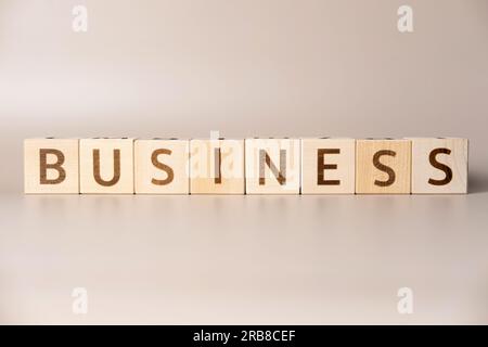 The word BUSINESS on wooden cubes on a beige neutral studio background. Copy Space. Written. Text words matter. Conceptual Photo. Career symbol. The c Stock Photo