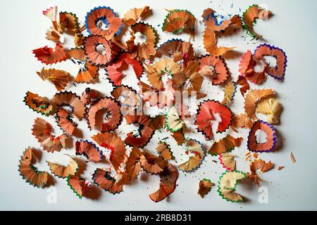 Shavings from colored pencils on white paper, top view. Creative concept. Stock Photo