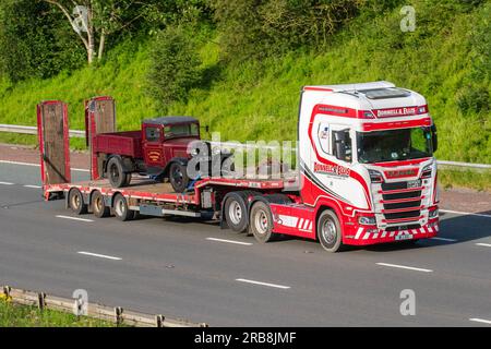 1933 30s thirties Maroon Bedford Sedan drop-side van, JN 3831 BEDFORD 2 TON TRUCK., L.J. Cullimore, Wotton-under-Edge, Glos, being carried on Nooteboom step trailer; travelling on the M6 motorway in Greater Manchester, UK Stock Photo