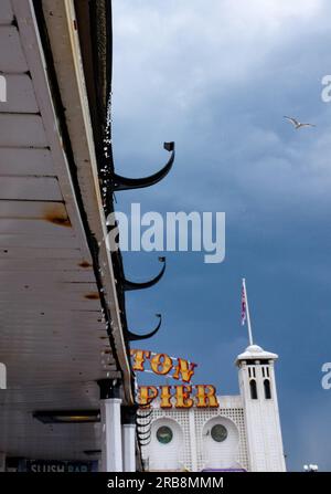 Brighton UK 8th July 2023 - Menacing dark clouds over Brighton Palace Pier as thunder storms sweep across parts of the UK today  : Credit Simon Dack / Alamy Live News Stock Photo