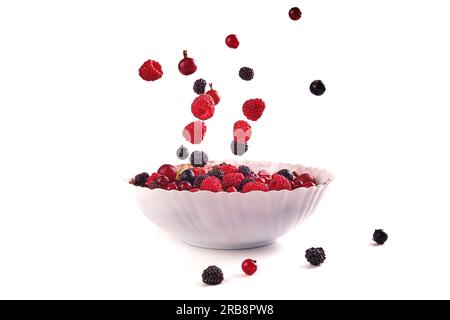 various berries, raspberry, currant on a plate isolate on white, berries are falling Stock Photo
