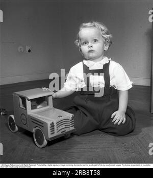 Children in the 1950s. A small boy sits neatly dressed and well-groomed with his toy, a Brio truck. The company Brio started manufacturing wooden toys already at the beginning of the 20th century. Sweden 1951. Kristoffersson ref BB41-8 Stock Photo