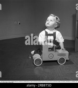 Children in the 1950s. A small boy sits neatly dressed and well-groomed with his toy, a Brio truck. The company Brio started manufacturing wooden toys already at the beginning of the 20th century. Sweden 1951. Kristoffersson ref BB41-6 Stock Photo
