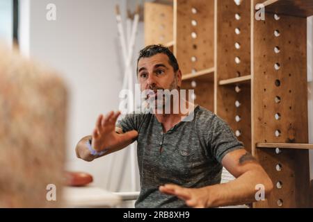 Handsome middle-aged project manager explaining very important things about the project to his employees Stock Photo
