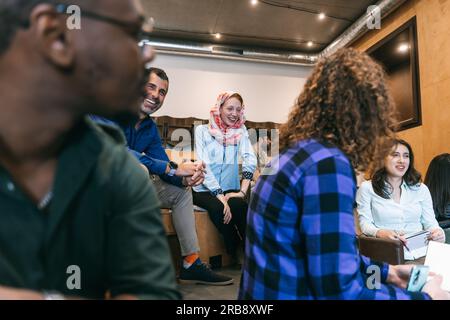 Diverse group of business people working in a good atmosphere. Multiracial, multicultural businesspeople working together, they are having fun convers Stock Photo