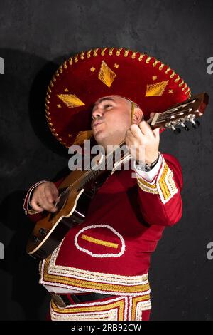 Mexican musician mariachi plays the guitar on a city street. Stock Photo