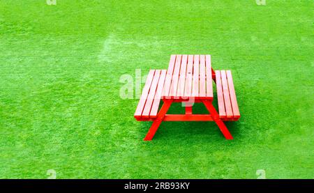 concept isolated red picnic bench on bright green artificial grass former battersea power station upmarket shopping centre  london uk Stock Photo