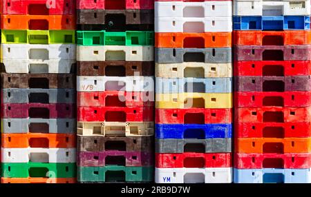 Stack of coloured or colored plastic fish boxes Stock Photo