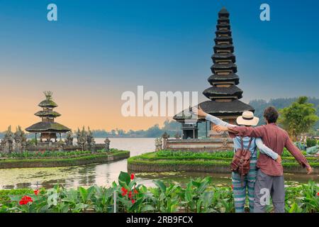 Couple spending time at ulun datu bratan temple in Bali. Wanderlust lifestyle exotic travel concept Stock Photo