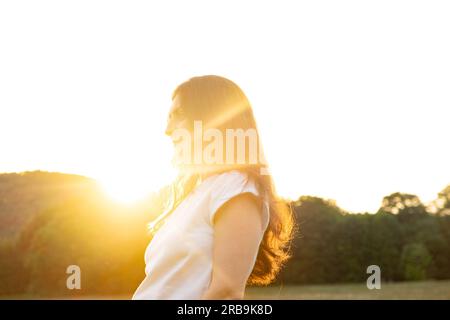 Dreamy pensive 35-year-old brunette woman in nature. The concept of unity with nature, feminine energy. Stock Photo