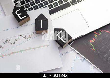 ETF - text on wooden cubes on a cold grey light background with stacks coins Stock Photo