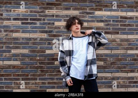 young man posing against a brick wall Stock Photo