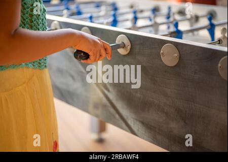 Hand playing foosball. People enjoying table soccer game. Stock Photo